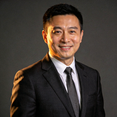 U8.COM国际业务高级副总裁张伟先生半身肖像照 - 身着深色西装，面带自信微笑